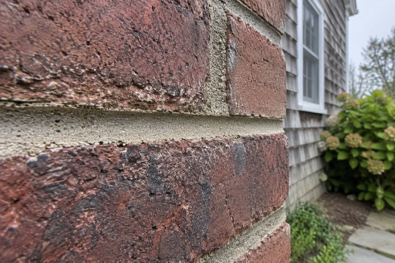 Close view of a freshly tooled concave mortar joint matched to the surrounding brick