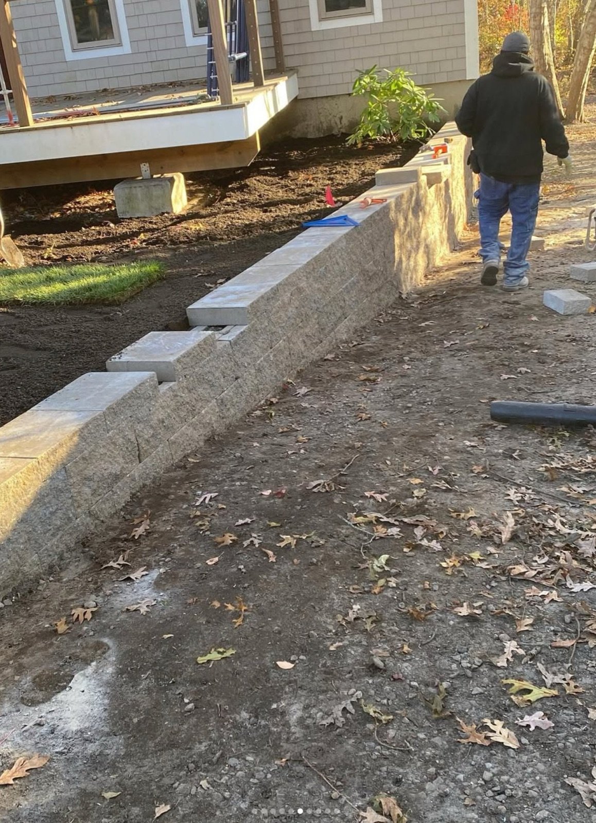 Block wall and steps under construction beside a path, with the base graded and ready