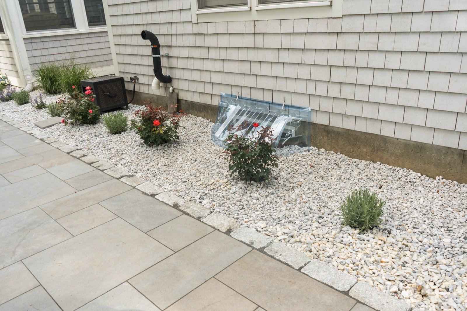 Large bluestone slabs set as a walkway beside a planting bed and shingled wall