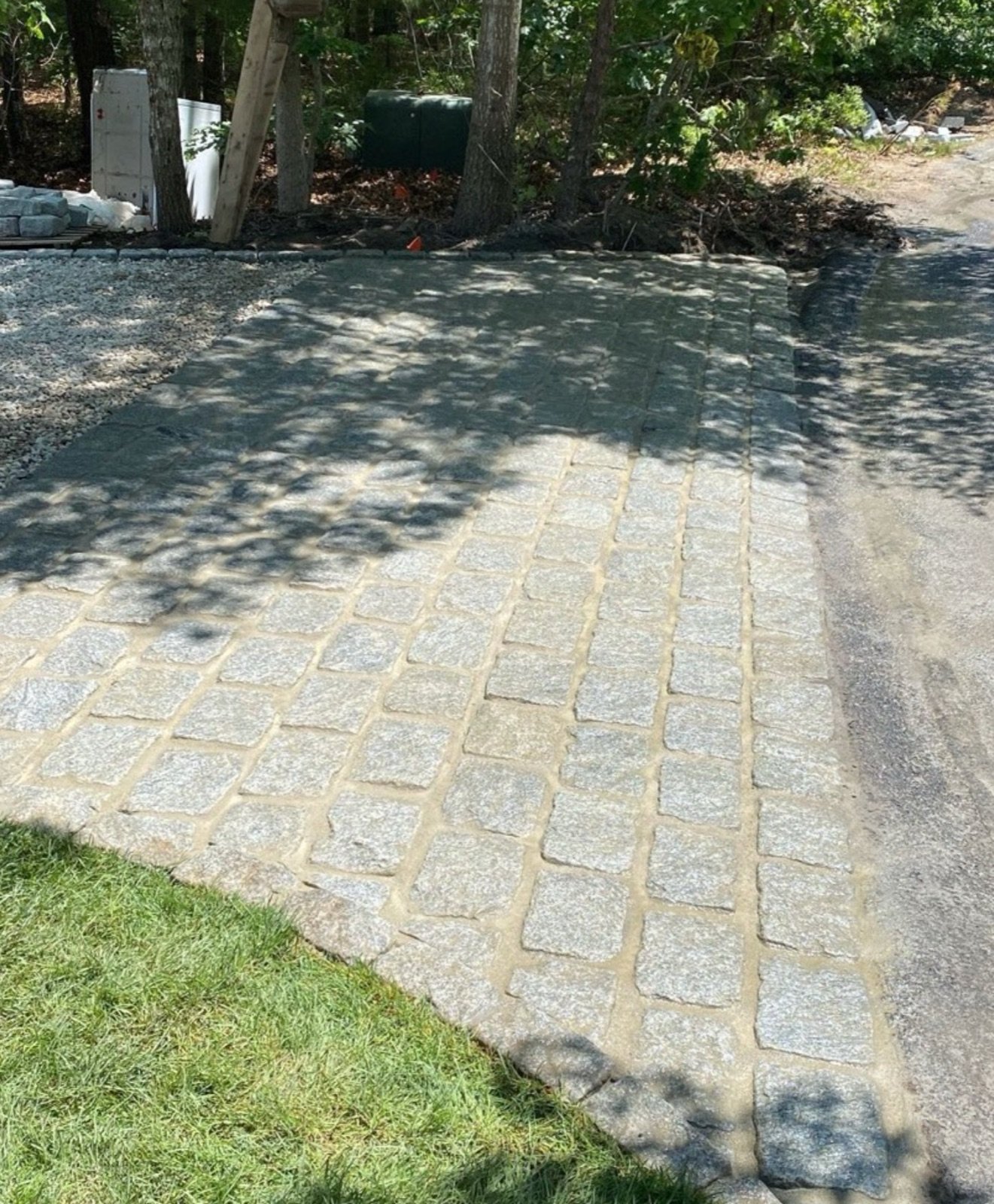 Paver patio laid in a tight interlocking pattern across a back yard