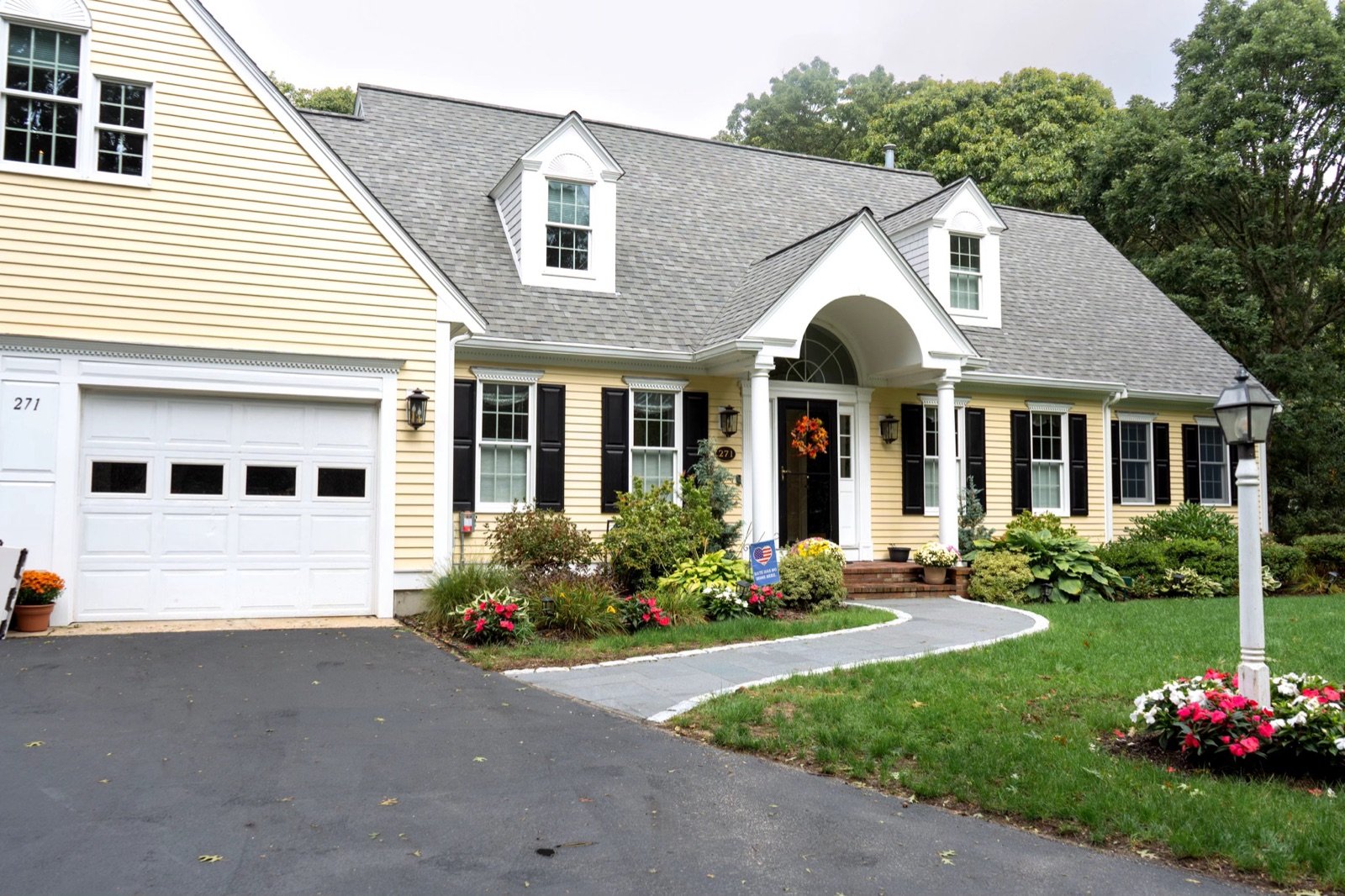 A Cape style home in South Yarmouth with foundation planting and a kept front lawn