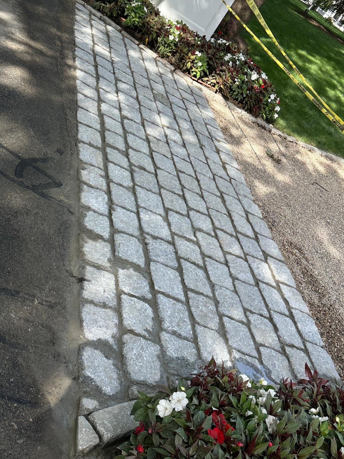 Close view of a cobblestone apron edge where the setts meet the asphalt