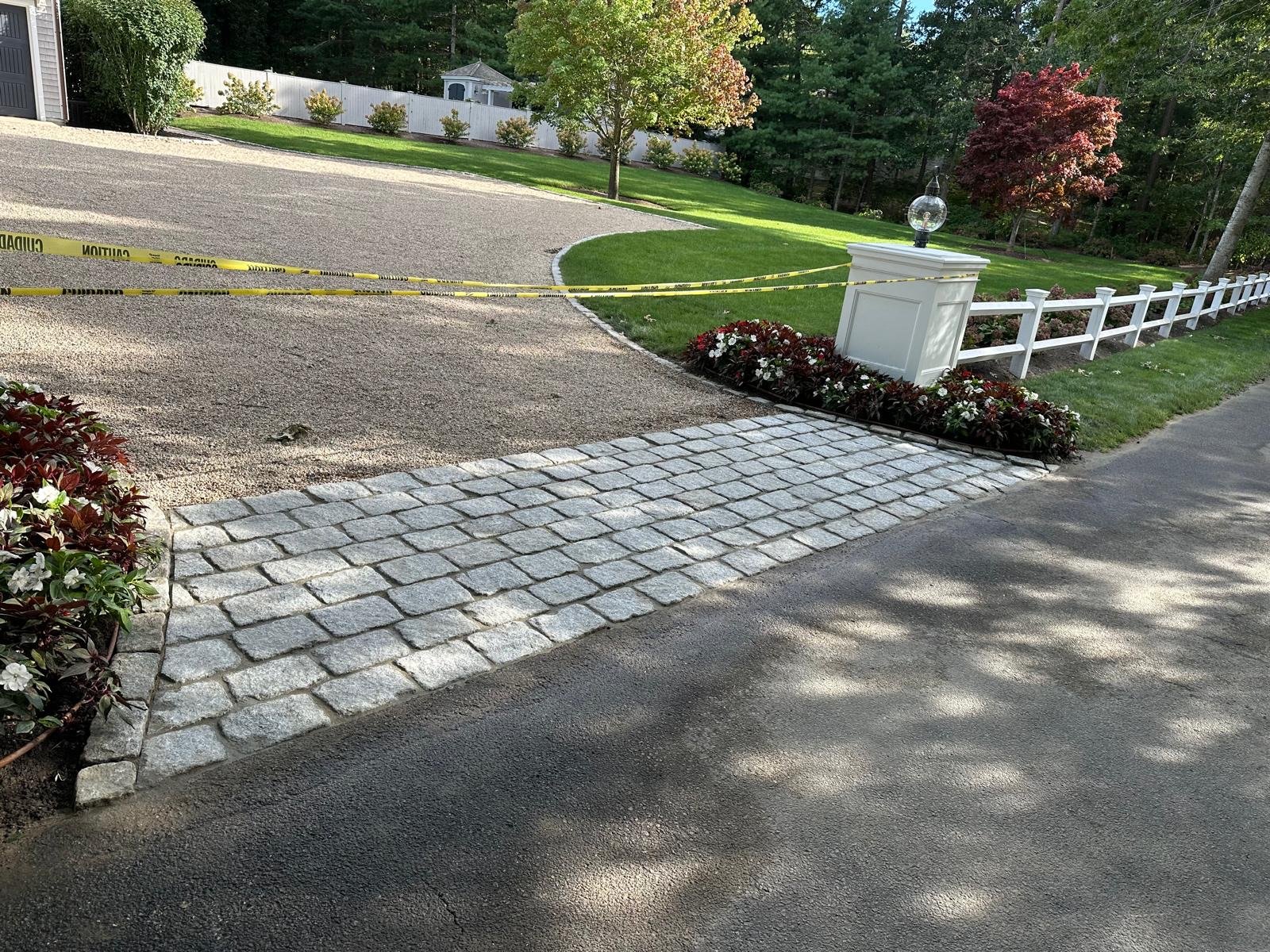 Cobblestone driveway apron laid at a gated entry in South Yarmouth, MA by Moriah Masonry & Landscaping