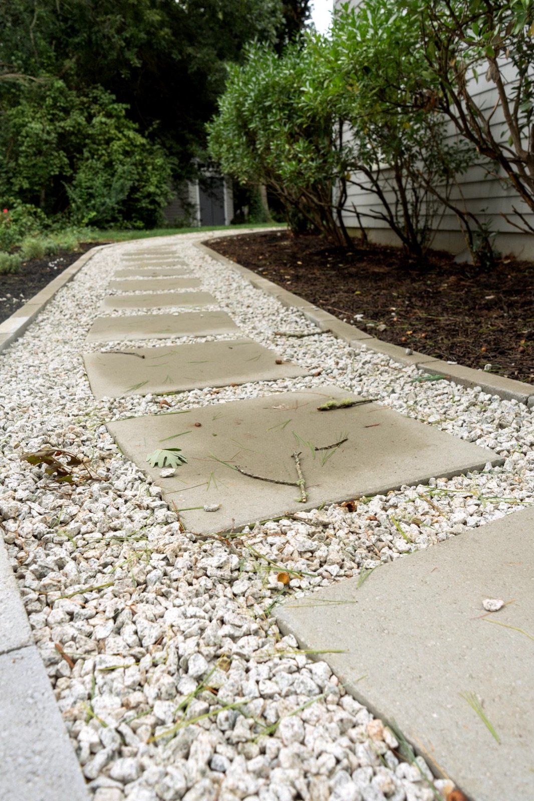 Poured concrete pads set as a path through a white gravel bed