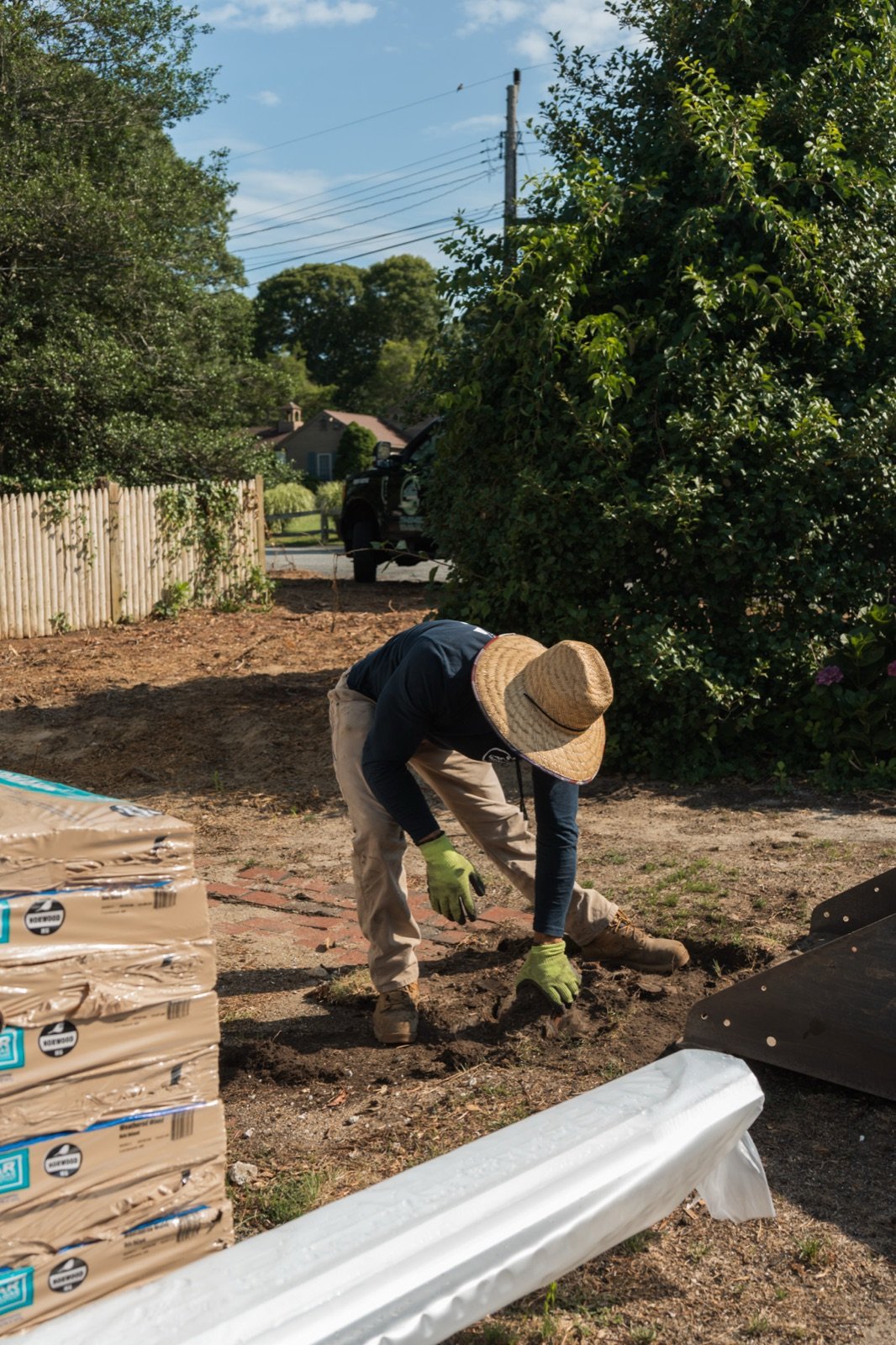 A crew member setting out a planting bed edge during site work
