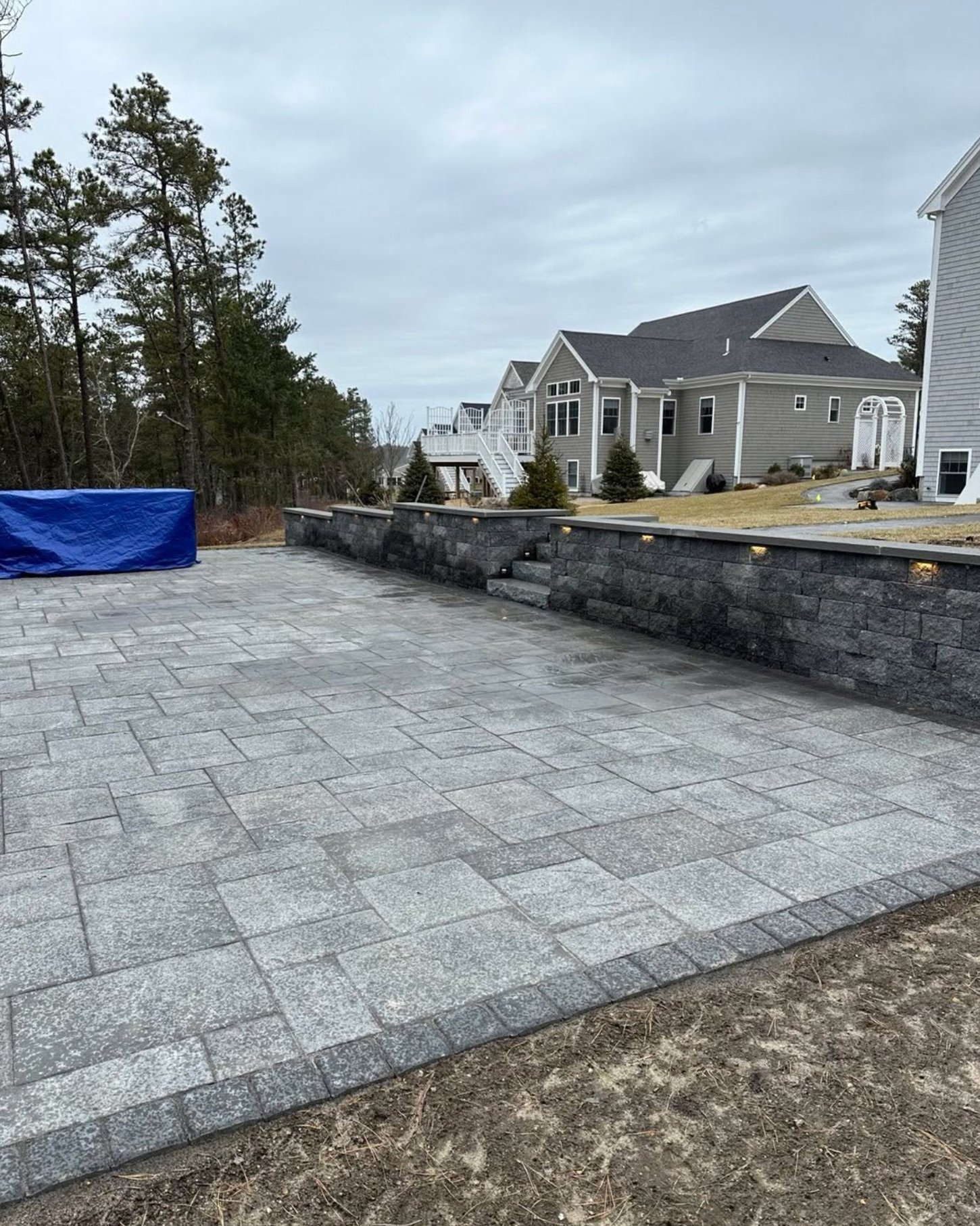 Large paver patio with a segmental block seat wall and low voltage lighting