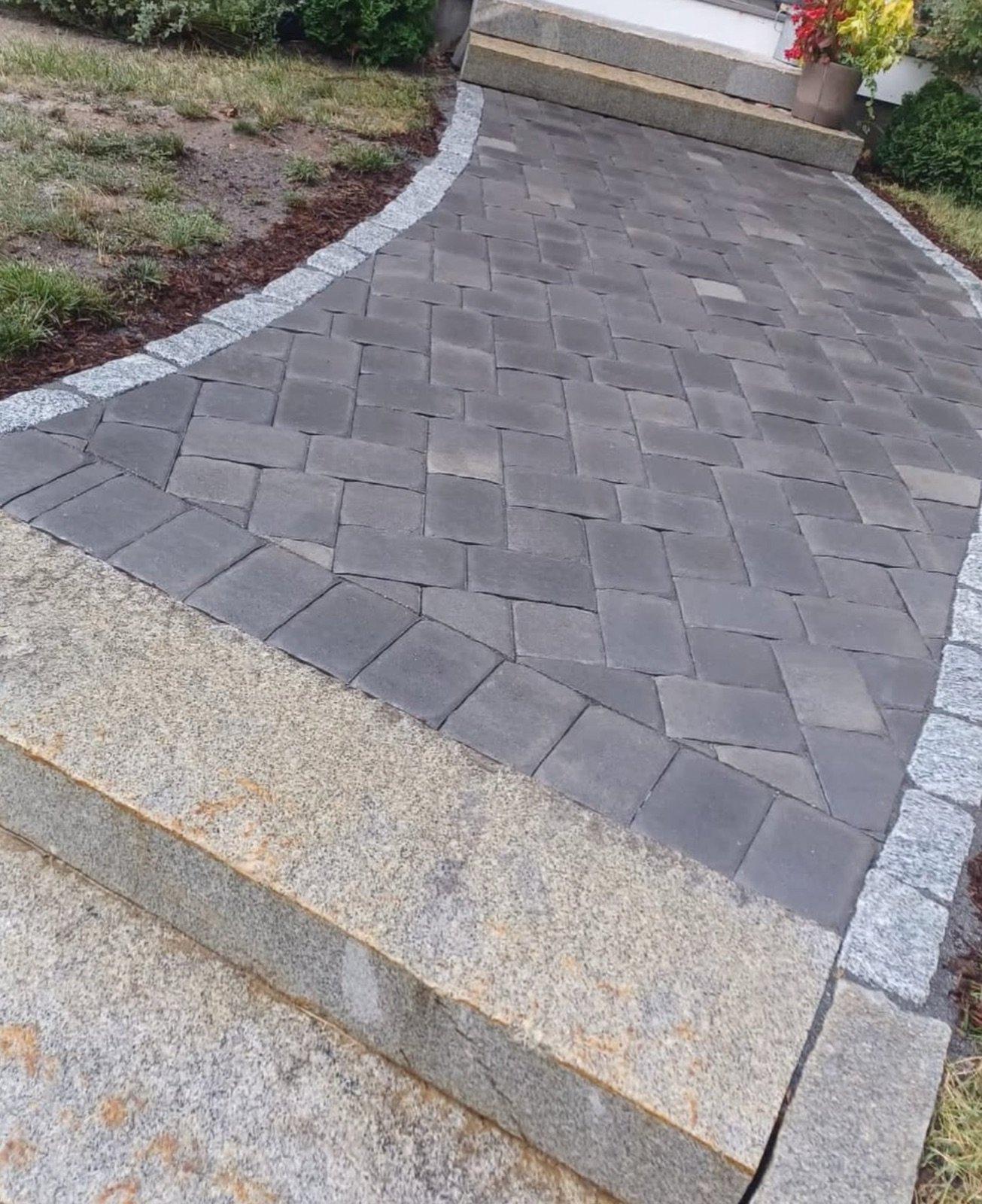 Paver walkway with a granite border running to a South Yarmouth entry