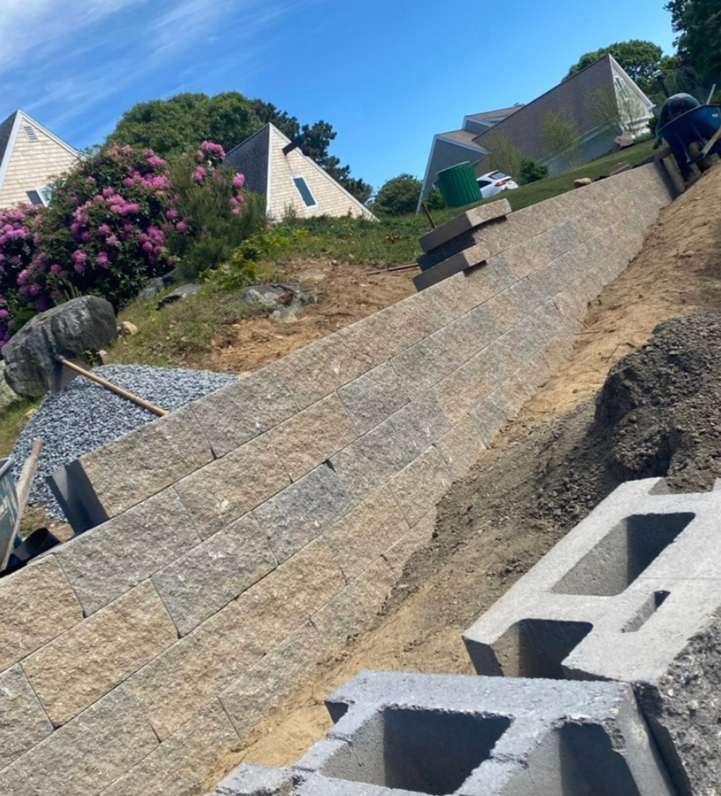 Retaining wall under construction with drainage stone behind it and the next course staged