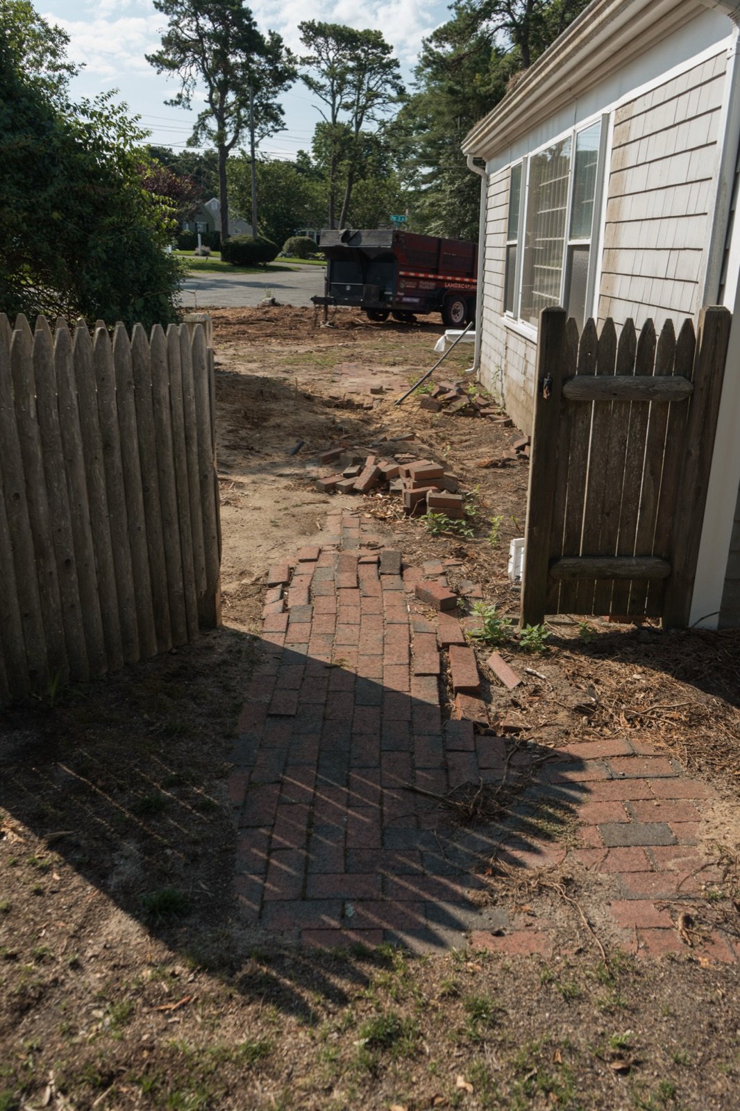 Bare graded ground where an old walkway surface has been removed before the new base goes in